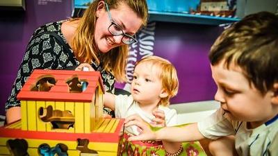 Parent and children playing with wooden toys